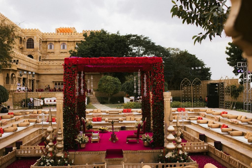 Decorated outdoor wedding pavilion and guest seating in front of a historic stone building